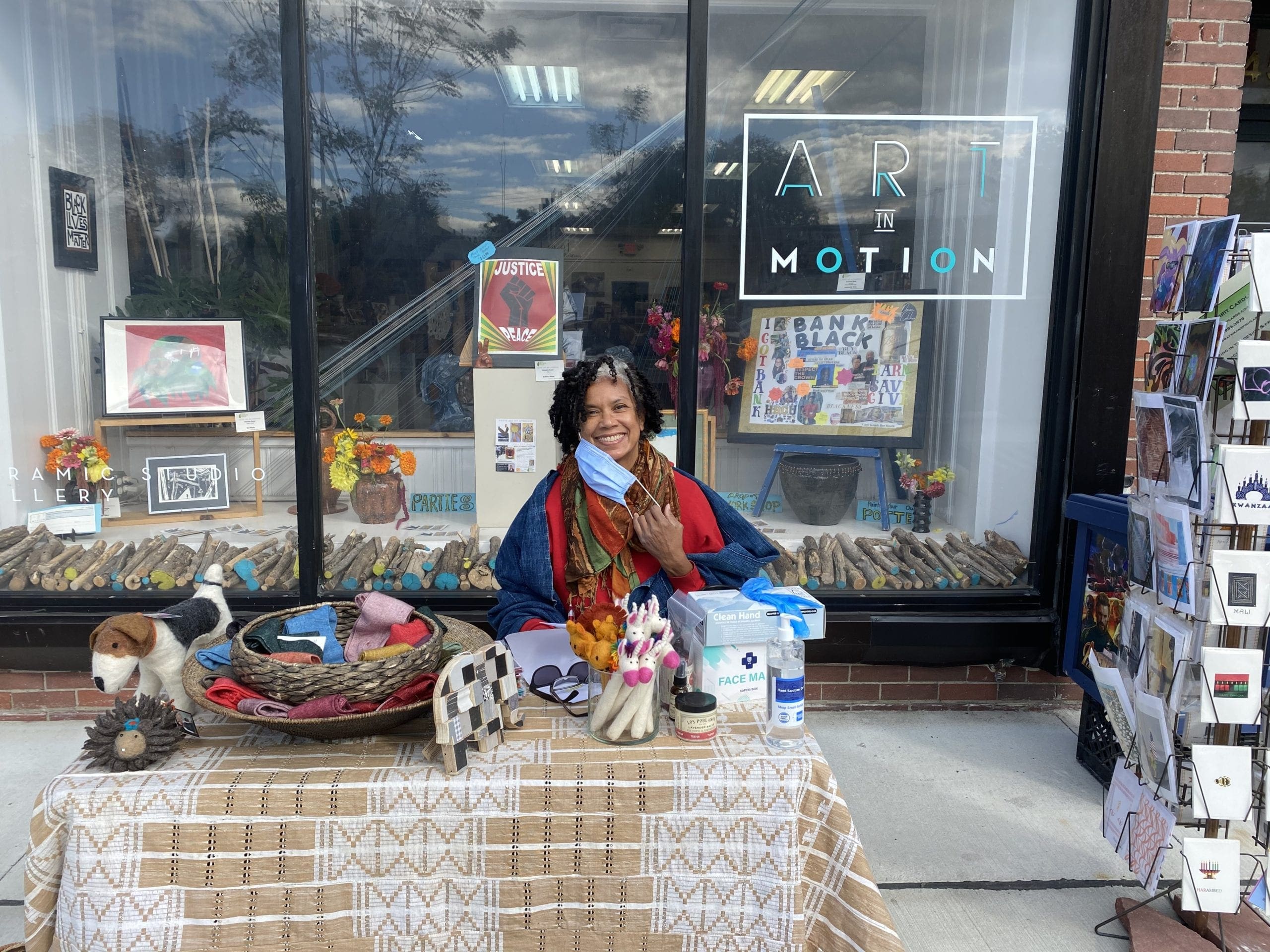 Shop owner is selling items outside of Art in Motion as a Small Business Saturday promotion